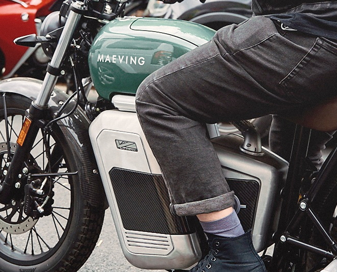 Maeving green electric motorcycle being ridden seamlessly in urban traffic